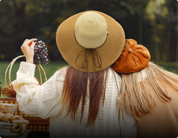 A girl is wearing an empire cove hat holding grapes