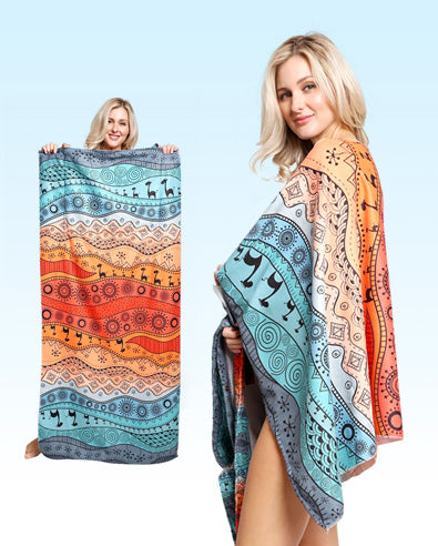 A woman showcases a reversible, patterned beach towel in blue and orange hues